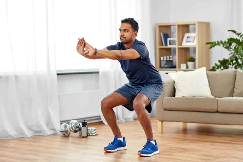 man squatting in living room