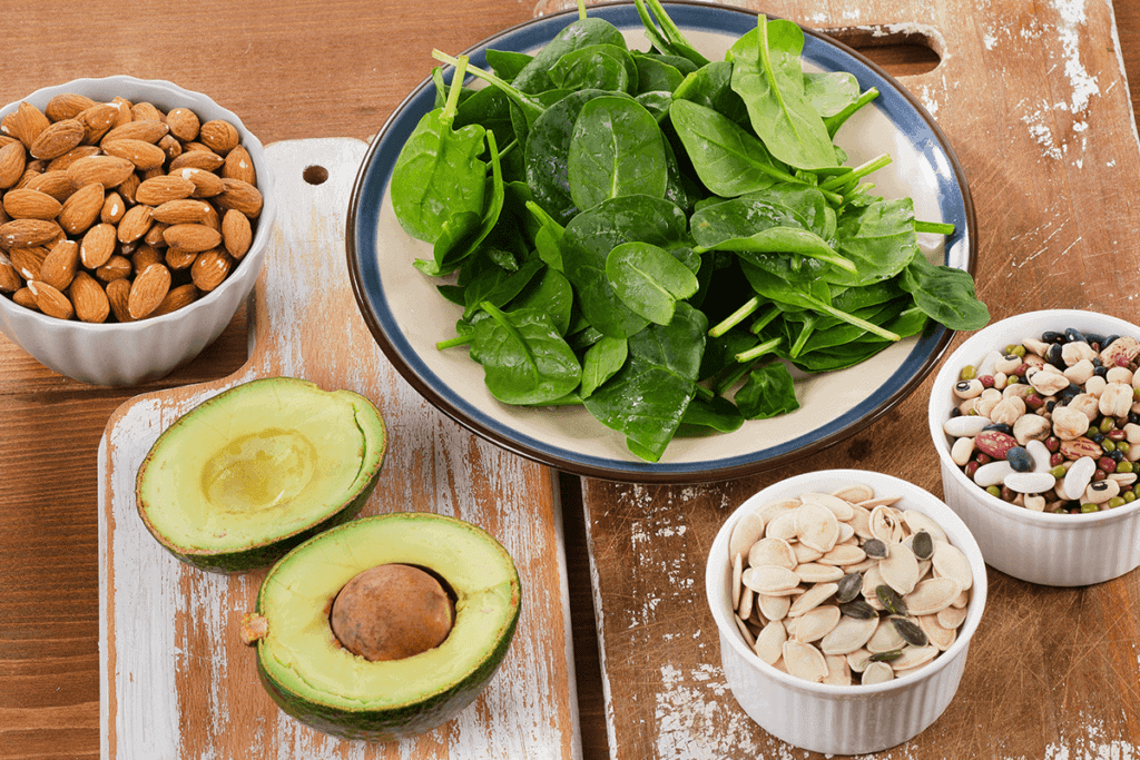nuts, beans, avocados, spinach in bowls and on plates
