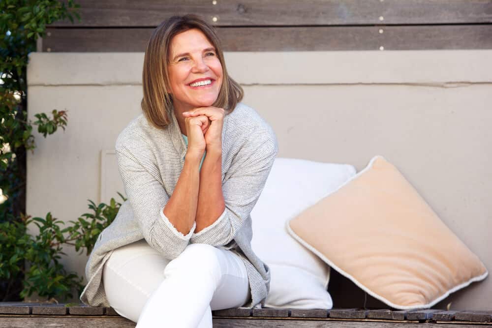 Healthy, smiling woman sitting on bench