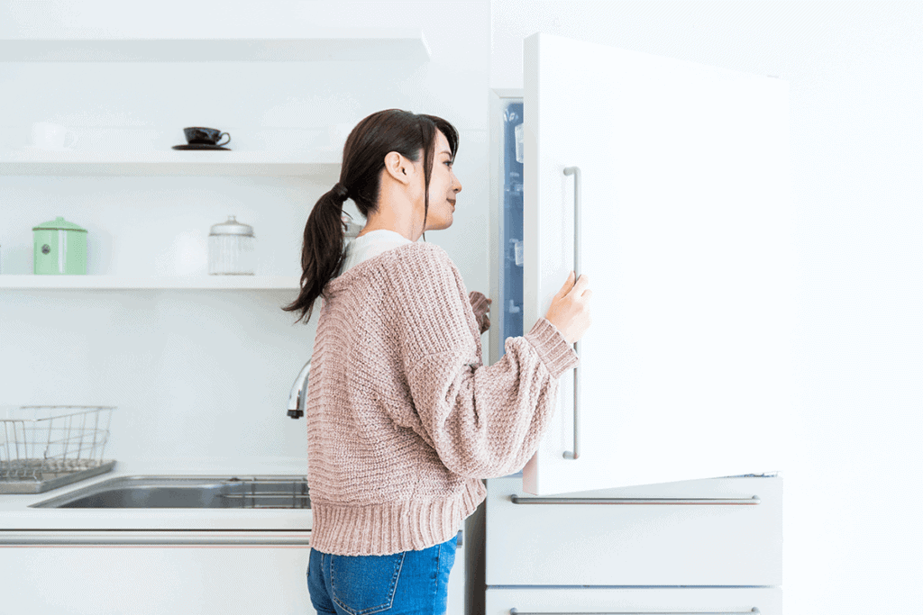 woman opening her refrigerator and looking inside