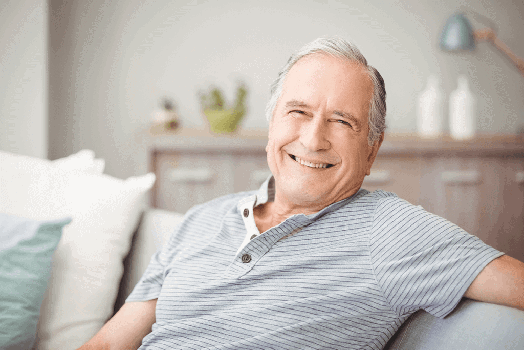 man smiling sitting on couch in living room