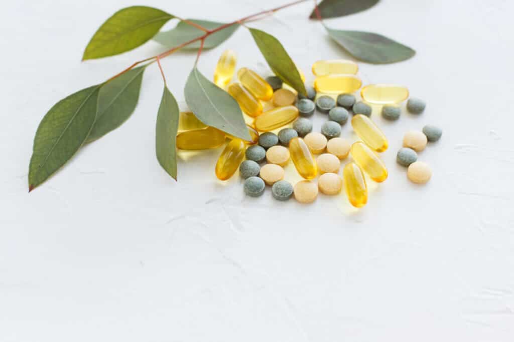 Herbal tablets and softgels against a white backdrop.