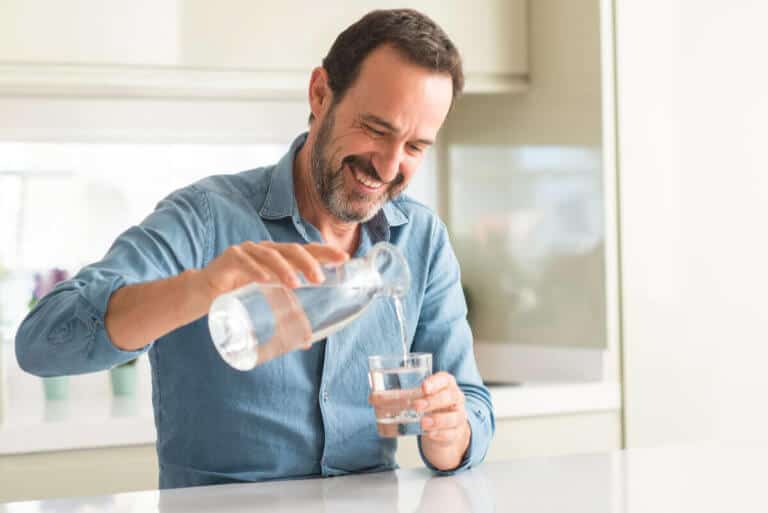 man pouring water in his kitchen