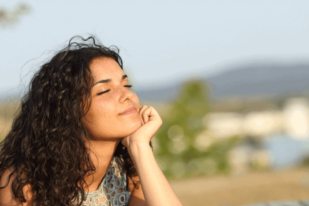 woman smiling with eyes closed in the sun