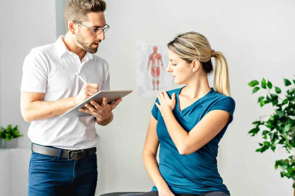 chiropractic taking notes and evaluating patient