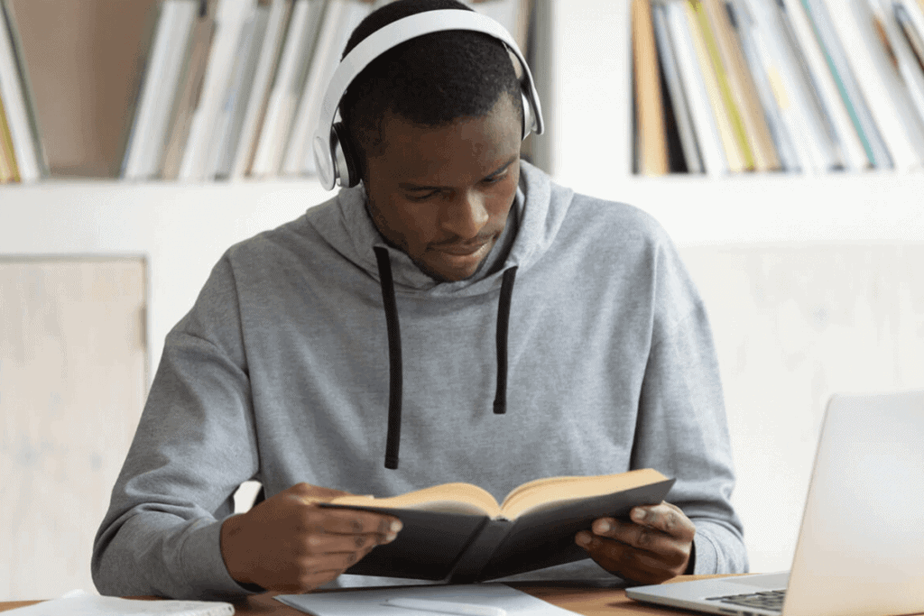medical student with headphones on, reading a book