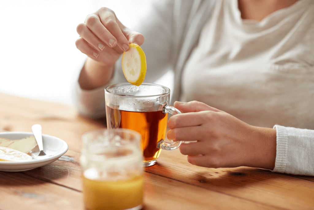 person adding ginger to tea