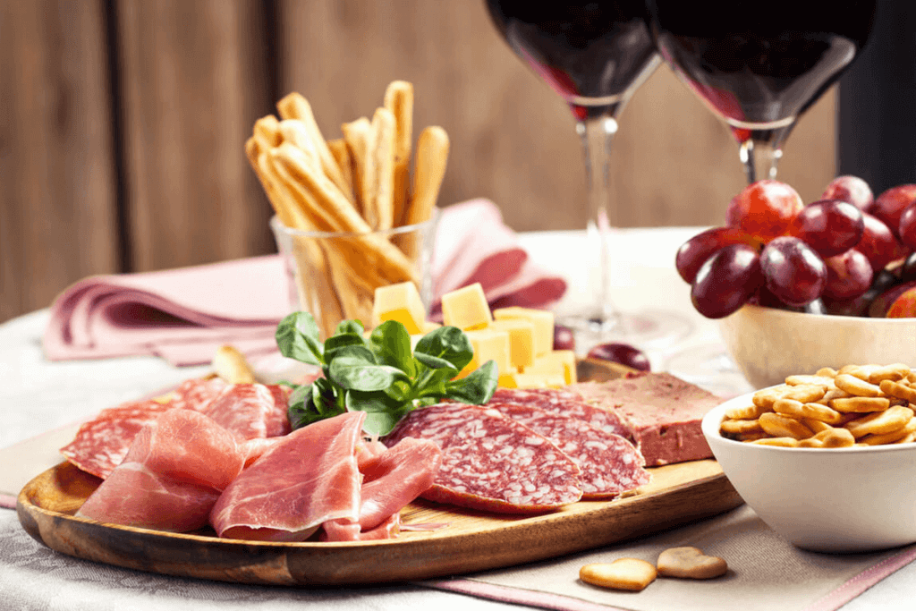 Wine, meat, and cheese snack board.
