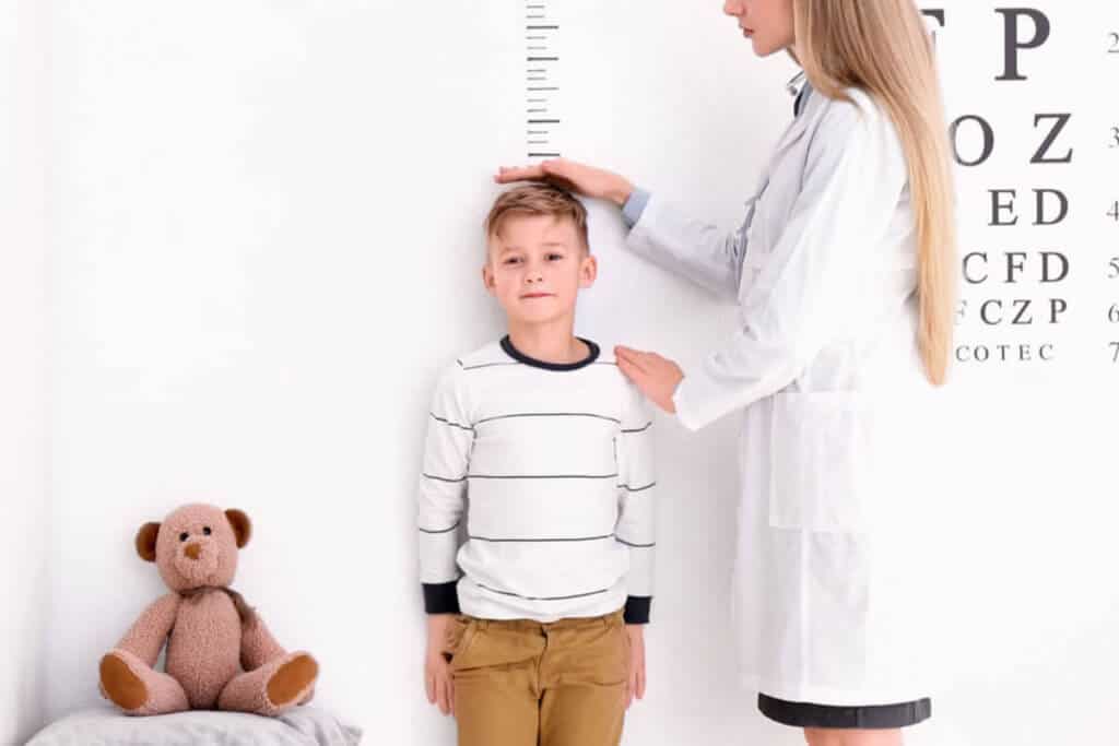 optometrist measuring the height of a boy