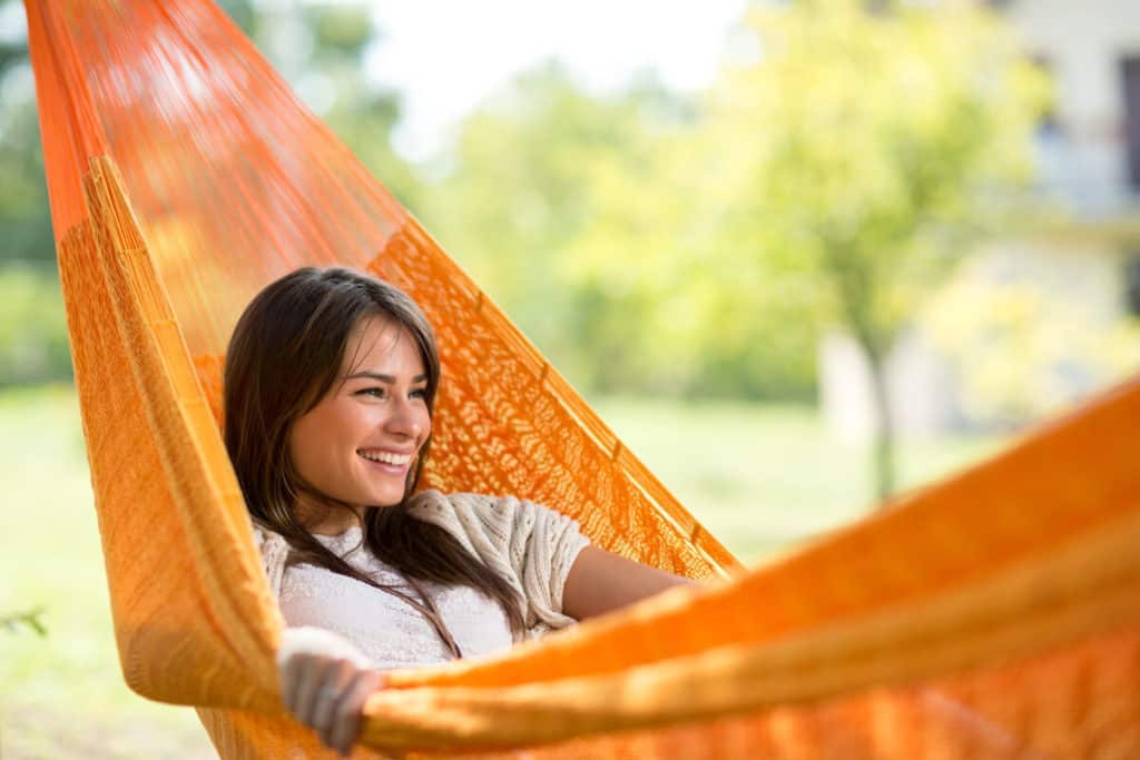 woman sitting in hammock outside