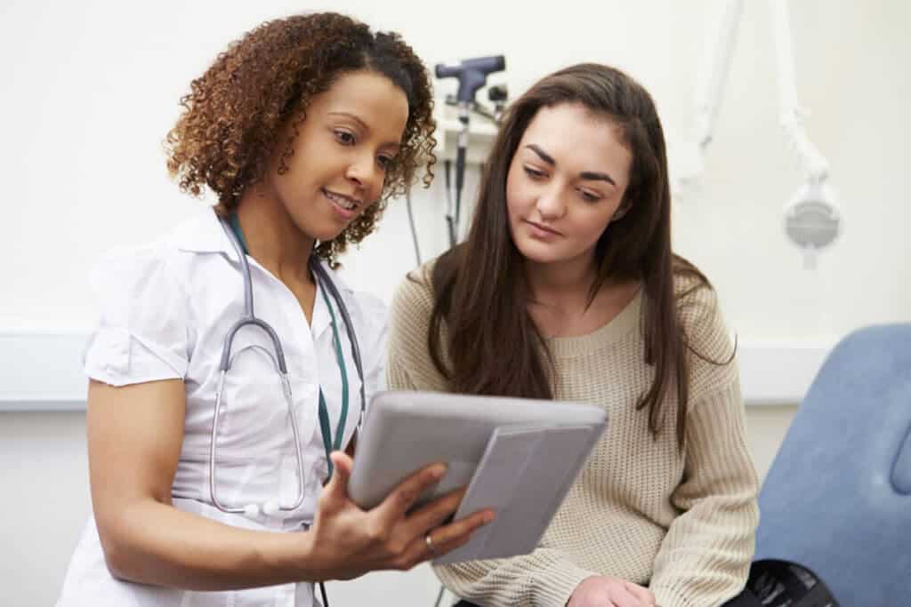 healthcare practitioner showing a patient information on an iPad