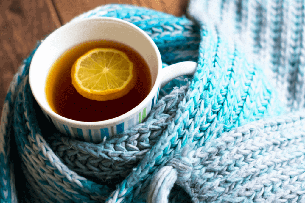 hot tea with a lemon slice in it wrapped by a scarf
