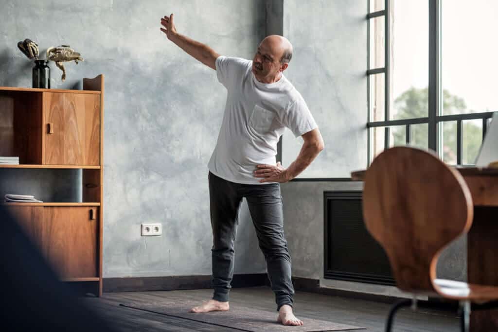 man stretching in his living room