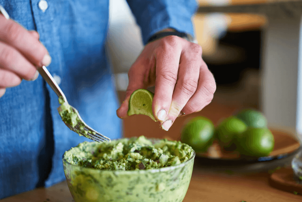 man making guacamole with french avocados and lime