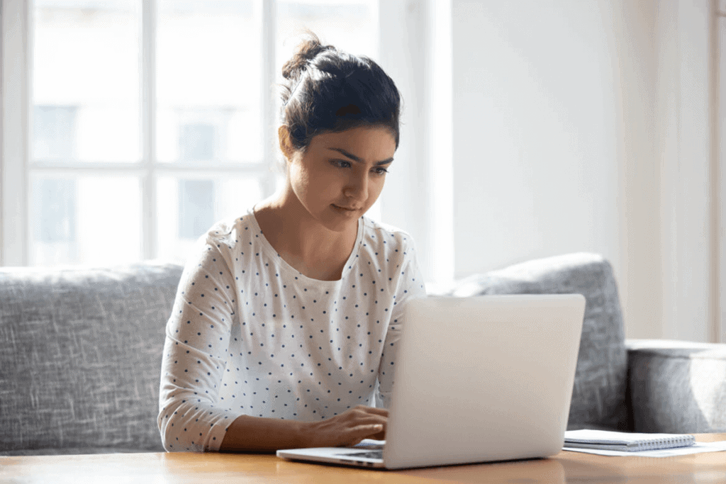 woman sitting on her couch working on her laptop