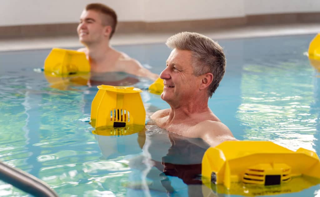 two men in pool doing water aerobic exercises
