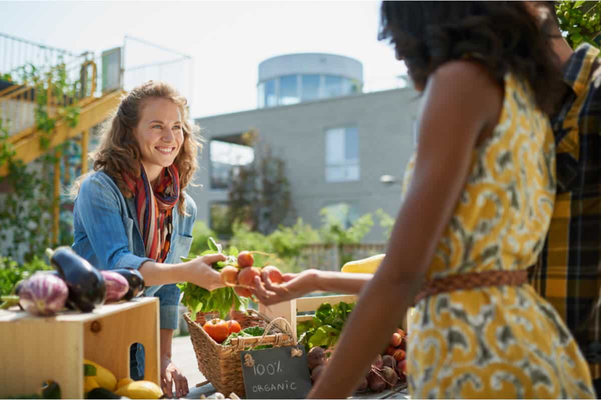 Women exchanging produce at a farmers market