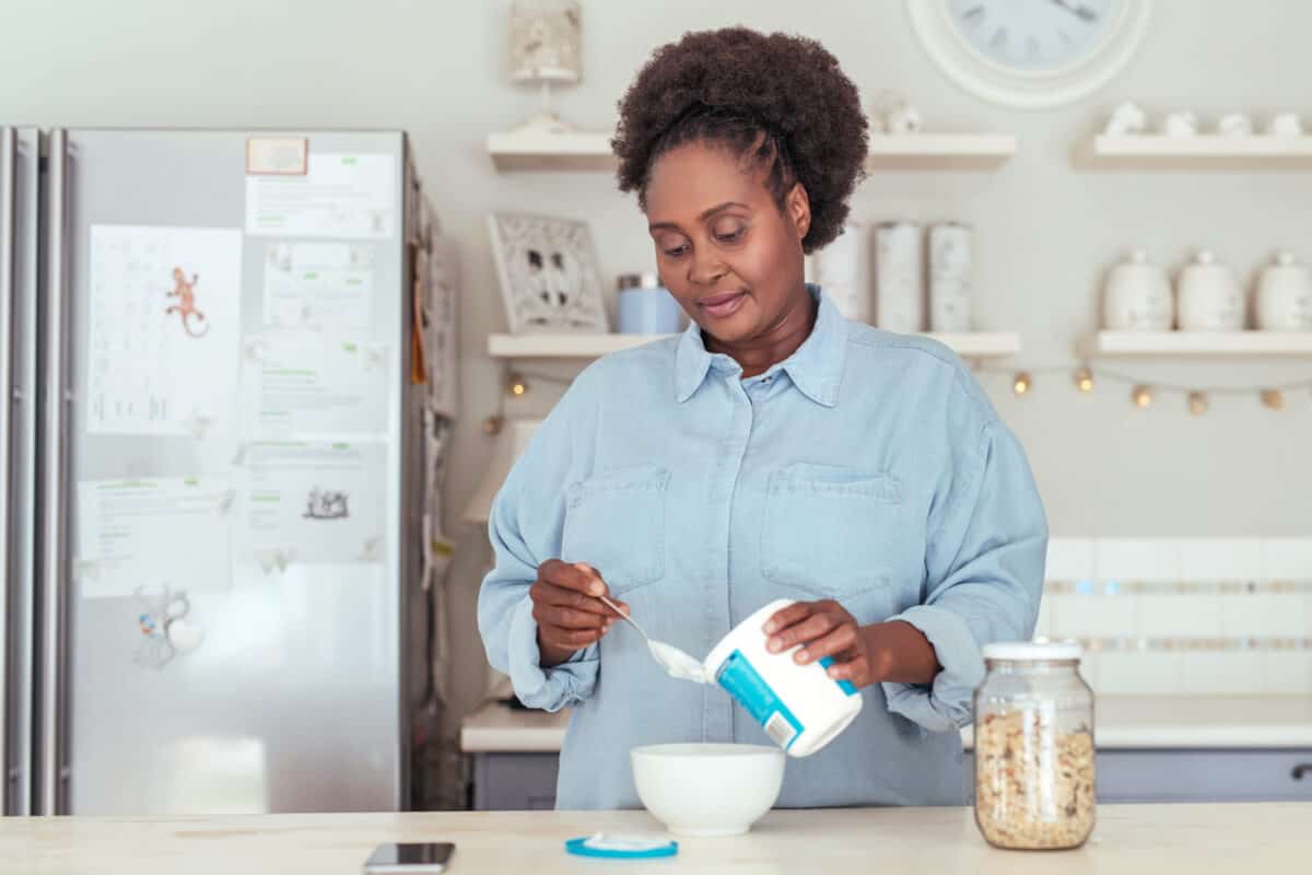 Woman scooping yogurt into a bowl