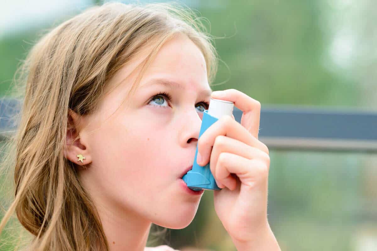 Young girl using an inhaler for an asthma attack