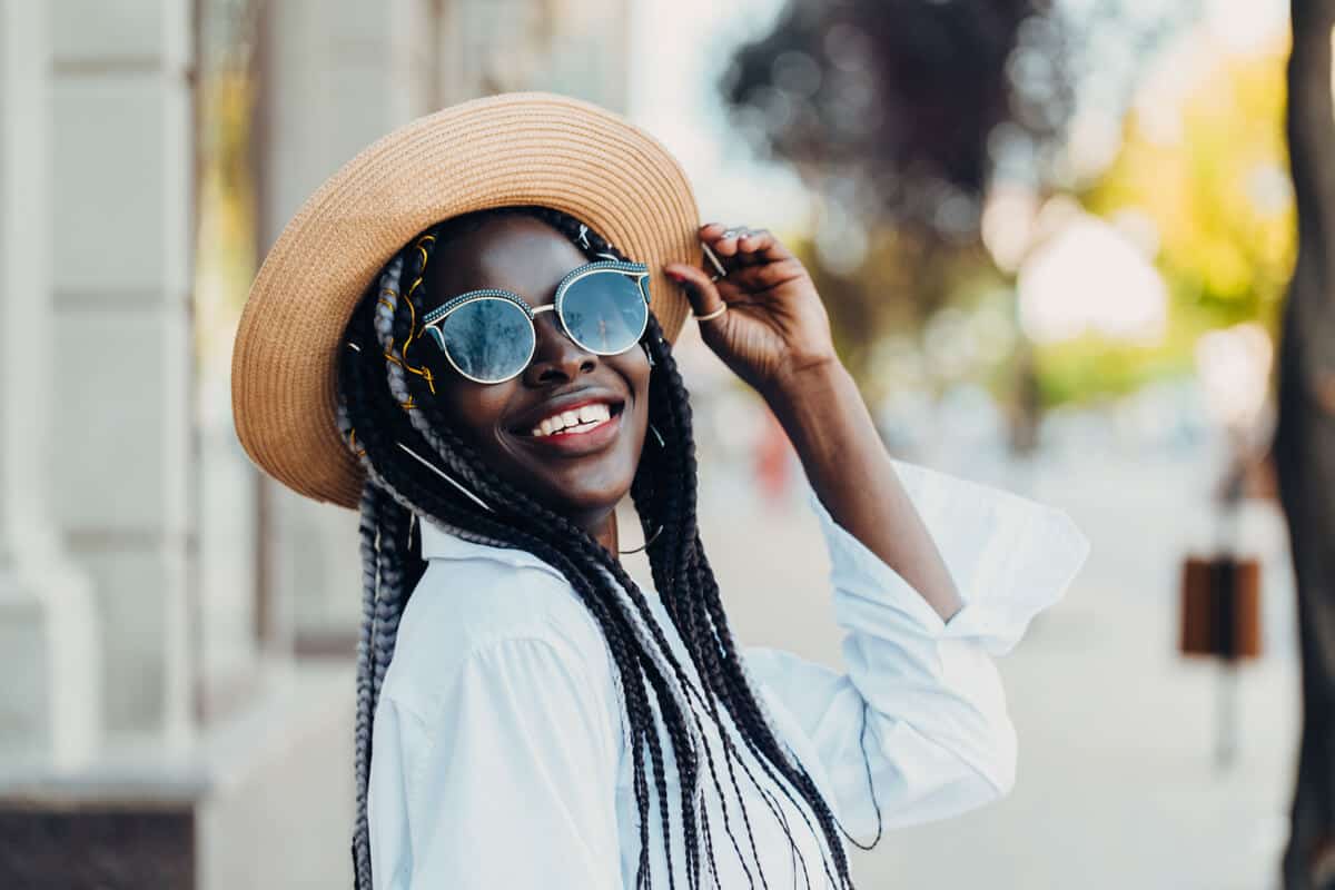 woman wearing a hat and sunglasses outdoors