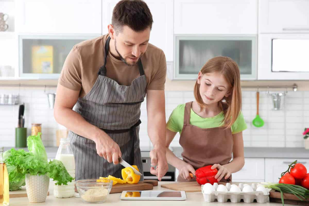 man and daughter cooking in the kitchen