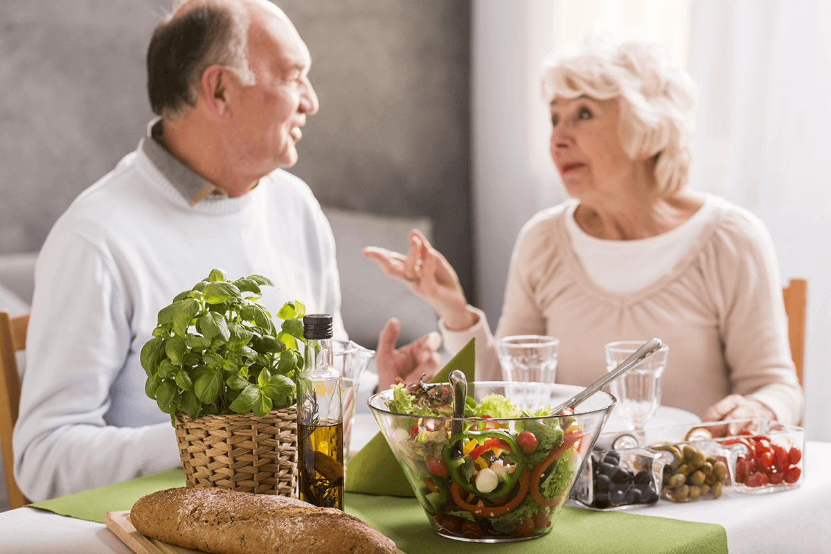a man and a woman talking over salad