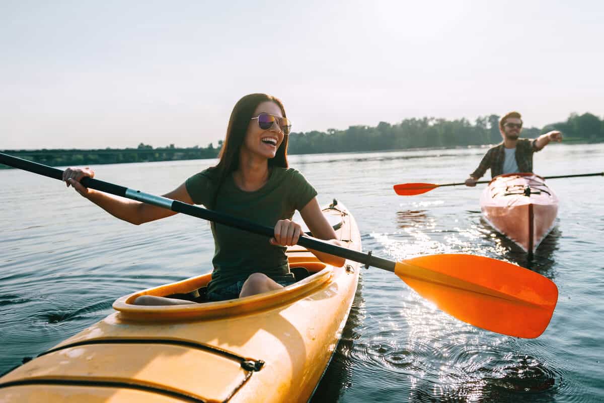 A man and a woman kayaking in a lake 