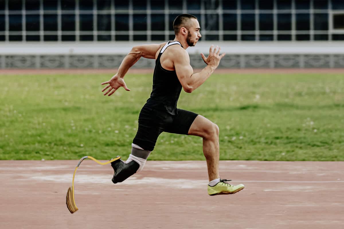 Man with an artificial leg running on a track