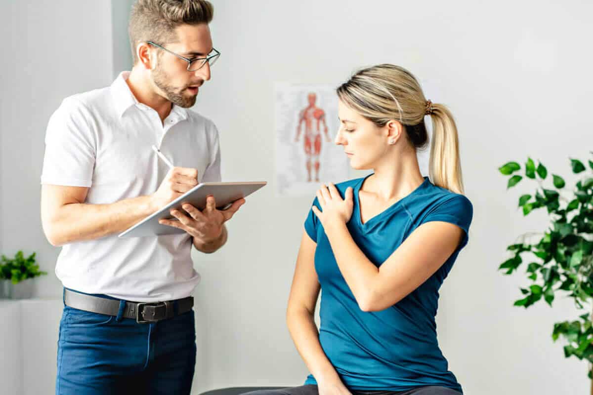 chiropractic taking notes and evaluating patient