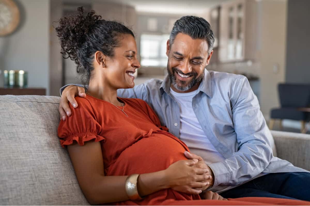 Pregnant woman and man sitting on a couch 