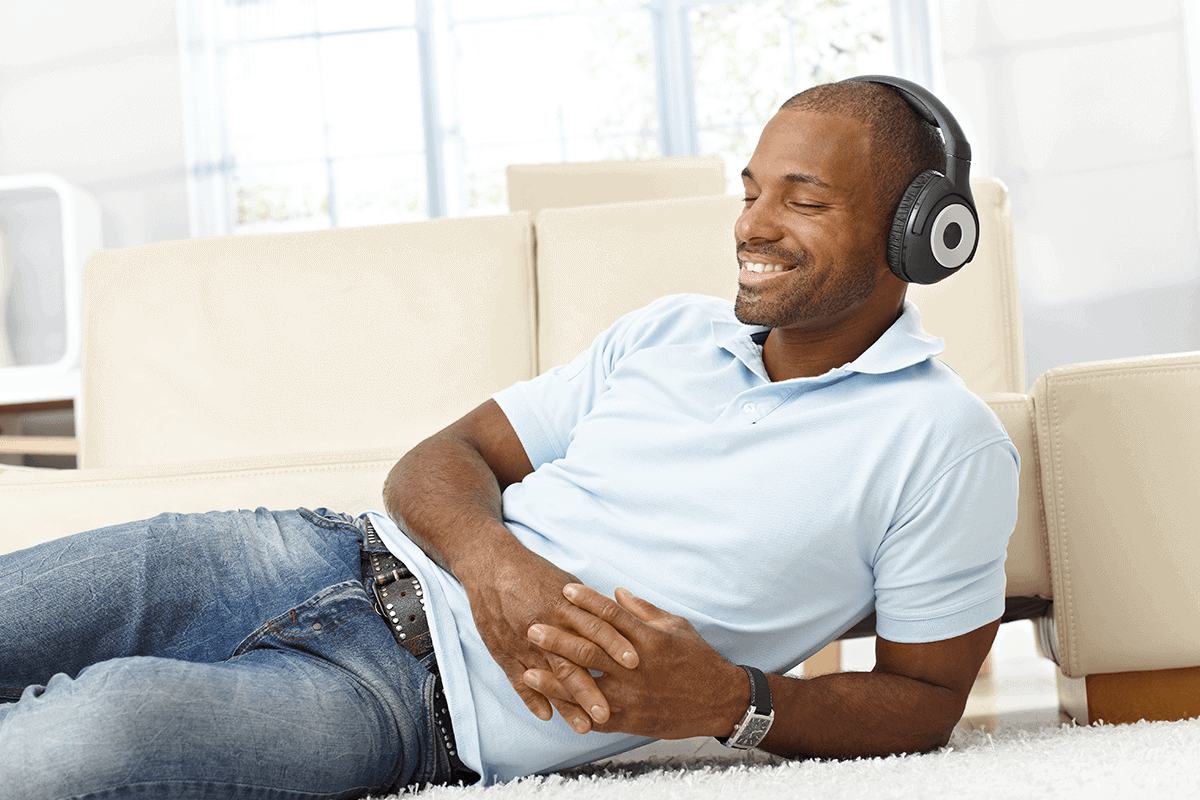 Man laying with headphones on smiling