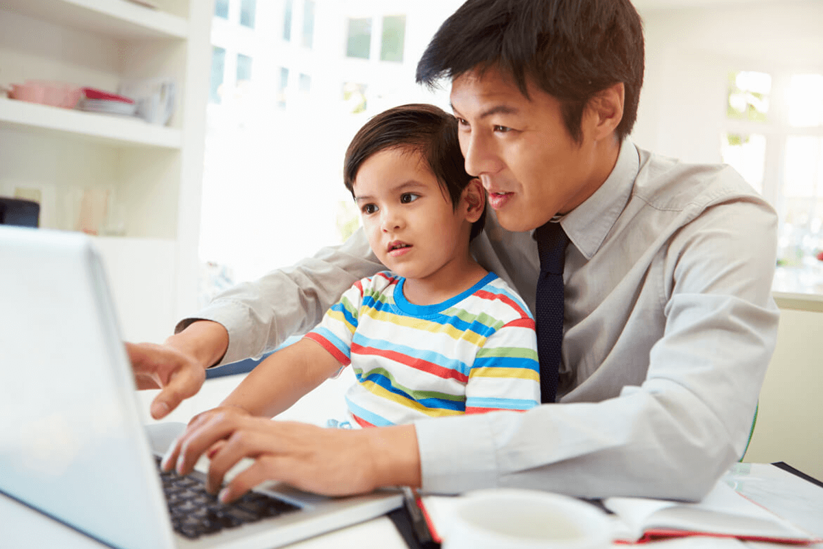 Father working on a computer with son