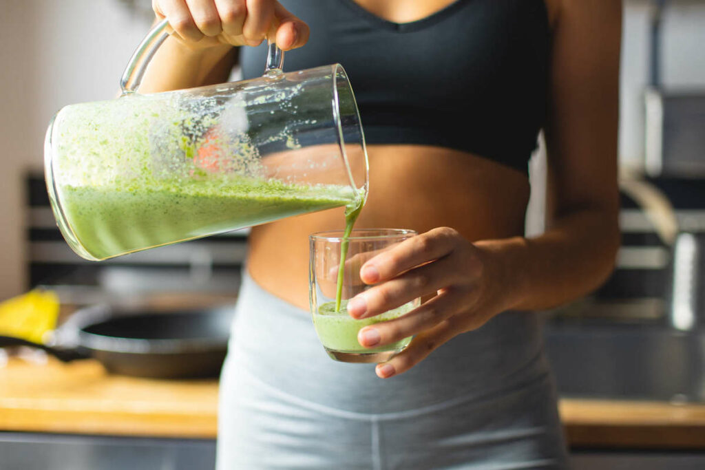 Women pouring a healthy green smoothie. 