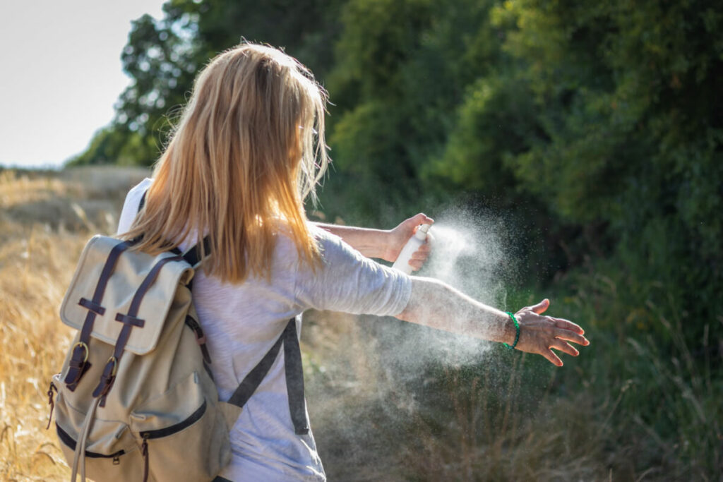 girl spraying bug spray