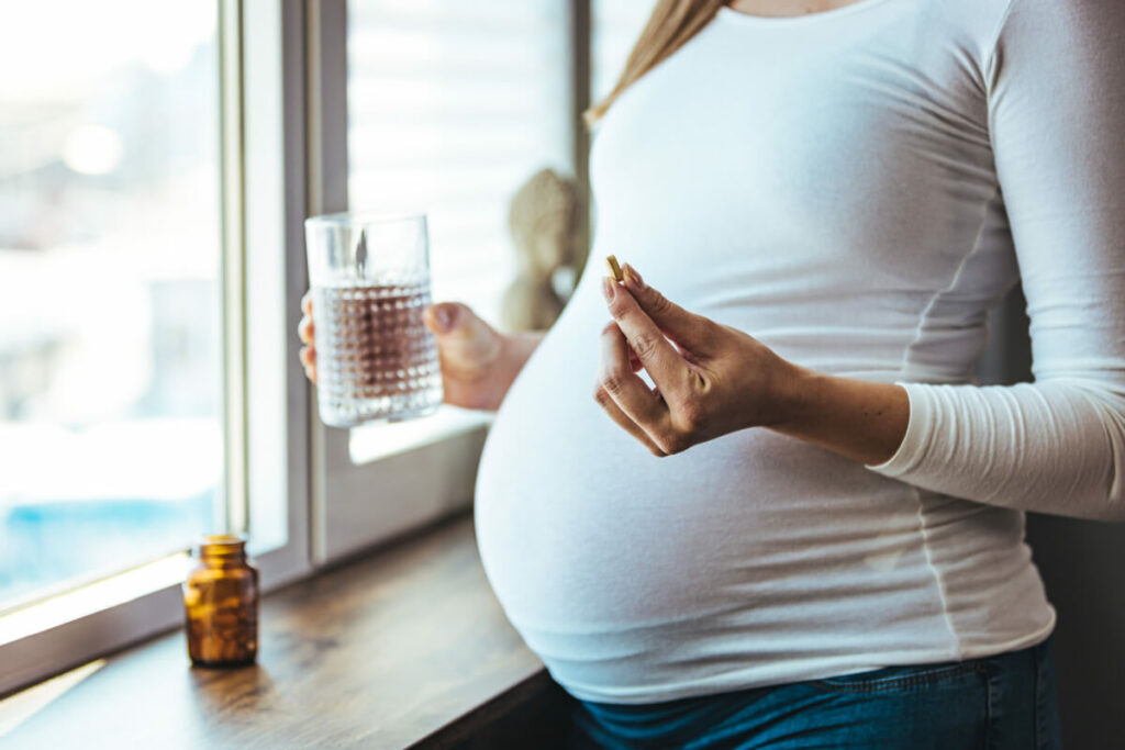 pregnant woman taking a supplement